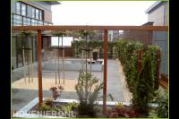 Strakke tuin met vijver, pergola en hedera schutting