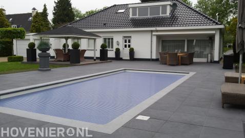 Villatuin met bestrating, zwembad en overkapping met vlonder
