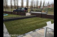 Plantenbak van stapelblokken in gazon van graszoden