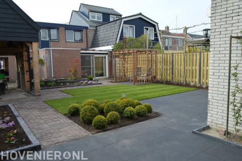 Tuin met gazon, pergola, hout beton schutting en leibomen 2