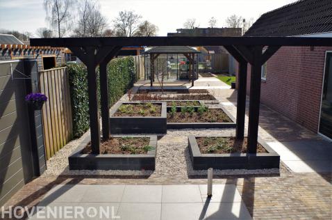 Tuinaanleg met bestrating, pergola en plantenbakken met nieuwe planten