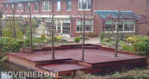 Hardhouten vlonder aan het water met leibomen