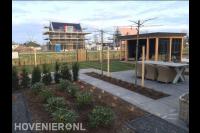 Tuinaanleg met gazon, bestrating en luxe houten veranda