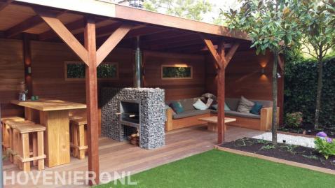 Loungebank, tuinhaard en eethoek onder hardhouten overkapping