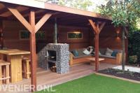 Loungebank, tuinhaard en eethoek onder hardhouten overkapping