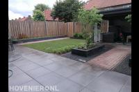Tuinaanleg met bestrating van betontegels en gazon