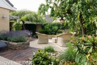 Groene tuin met terras en bloembakken met lavendel