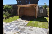 Tuinaanleg met bestrating, graszoden en houten overkapping