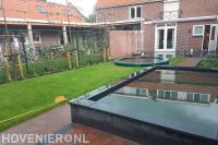 Tuinaanleg met bestrating, vijver, gazon en trampoline