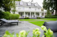 Achtertuin met veranda, terras en gazon