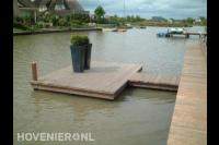 Houten vlonder met buxusbollen in hoge bloembakken