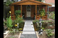 Tuinaanleg met vijver en houten tuinhuis met veranda