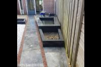 Tuinaanleg met sierbestrating, grind en plantenbakken met vijver