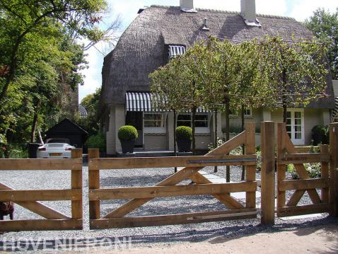 Villa tuin met houten inrijpoort bij oprit