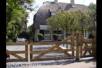 Villa tuin met houten inrijpoort bij oprit