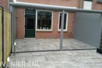 Achtertuin met terrasoverkapping en bestrating van natuursteen