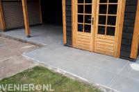 Bestrating van siertegels bij tuinhuis met overkapping