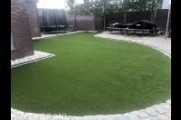 Achtertuin met kunstgras en bestrating met kasseien 2