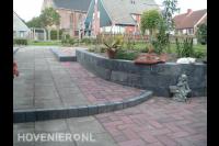 Bestrating van betontegels en klinkers en verhoogde border
