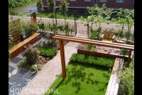 Moderne gezinstuin met pergola, vlonder en zitbankjes