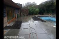 Straatwerk van grote tuintegels in tuin met zwembad