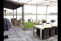 Tuin aan het water met overkapping, vlonder, terras en gazon