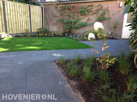 Kleine tuin met kunstgras, terras en hout beton schutting 1