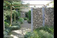 Moderne tuin met schanskorven, pergola en siergras