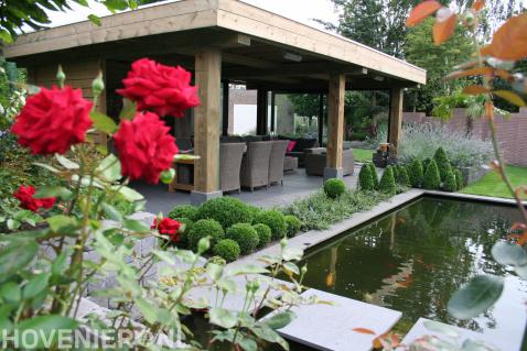 Tuin met vijver en houten terrasoverkapping