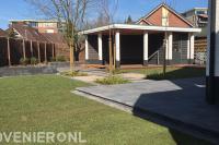 Tuinaanelg met bestrating, gazon, overkapping en schutting