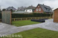 Tuinaanleg met bestrating, graszoden, plantenbakken en houten tuinhek