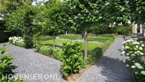 Klassieke tuin met hortensia's naast looppaden