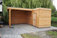 Bestrating van betontegels en houten schuurtje met overkapping