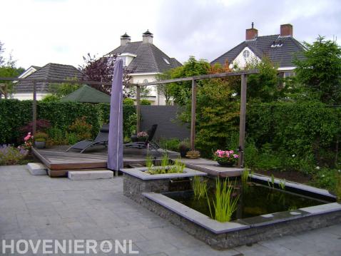 Houten vlonder en pergola bij kleine vijver