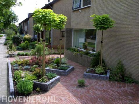 Kleine voortuin met bolcatalpa's in plantenbakken van stapelblokken