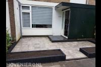 Voortuin aanleggen met plantenbakken en natuursteen tuintegels