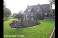 Voortuin met groot gazon en border met nieuwe beplanting