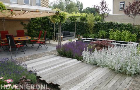 Tuinaanleg met vijver, vlonder en terras met pergola en schaduwdoek