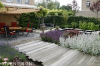 Tuinaanleg met vijver, vlonder en terras met pergola en schaduwdoek