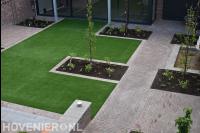 Tuinaanleg met gazon van kunstgras en bestrating van oude klinkers