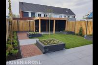 Tuinaanleg met bestrating, overkapping, plantenbakken en schutting