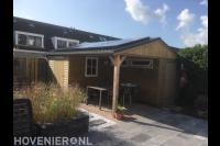 Houten schuurtjes met overkapping en zonnepanelen