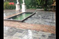 Nieuwe bestrating rondom strakke vijver