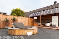 Tuin met maatwerk loungebank en tuinkamer
