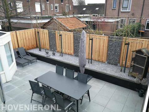 Moderne tuin met bestrating, verhoogde border, leibomen en schutting