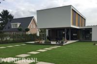 Gazon met stapstenen en terras bij moderne villa