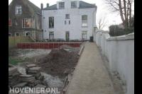 Houten beschoeiing voor verhoogd terras in tuin met hoogteverschil