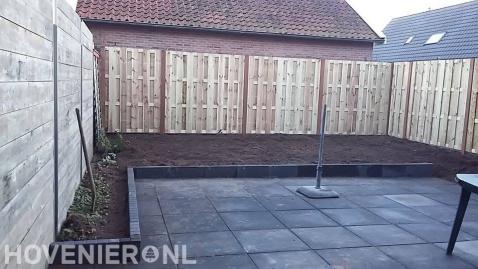 Tuinaanleg met bestrating, border en houten schutting