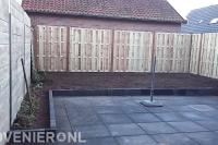 Tuinaanleg met bestrating, border en houten schutting