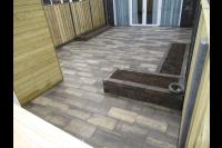 Achtertuin met natuursteen tegels en plantenbakken